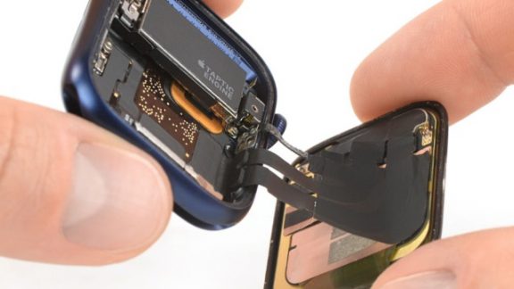 هنگامی که اپل در هفته گذشته ساعت‌های سری 6 خود را معرفی کرد، مقدار قابل توجهی از صحبت‌های این شرکت صرف سنسور جدید این سری ساعت‌ها برای اندازه‌ گیری سطح اکسیژن خون شد. اما به نظر می‌رسد که جدیدترین اپل واچ دارای چندین پیشرفت قابل توجه اما کوچکتر در زیر سنسور جدید خود است. سایت معروف Ifixit طبق معمول با باز کردن این ساعت دریافت که هر دو مدل 40 میلیمتری و 44 میلی متری سری 6 از باتری‌های بزرگتری نسبت به مدل‌های سری 5 خود برخوردار هستند. نوع 44 میلی متری دارای باتری‌ای با 3.5 درصد ظرفیت بالاتر از سری 5 آن است، در حالی که مدل 40 میلی متری دارای 8.5 درصد افزایش به نسبت مدل قبلی است. از آنجا که اپل هنوز ادعا می کند که با یک بار شارژ قابلیت 18 ساعت استفاده مداوم را دارد (درست مانند آنچه در سری 5 دیدیم) به نظر نمی‌رسد که باتری بزرگتر روی مقدار عمر باتری تأثیر بگذارند. ویژگی دیگری که در سری 6 بزرگتر است، موتور Taptic است. این بار نیز اپل از 100 درصد بازیافت فلزات خاکی کمیاب و تنگستن برای ساخت آن استفاده کرده است. در اواخر سال 2019، اپل اعلام کرد که شروع به تولید موتور Taptic آیفون از قطعات بازیافتی می‌کند. یک سال بعد، این کار را در اپل واچ هم انجام می‌دهد. با تکه تکه کردن این ساعت توسط این وبسایت، حذف Force Touch برجسته‌تر شد. ما می‌دانستیم که این ویژگی در زمانی که اپل WatchOS 7 beta را در ماه ژوئن منتشر بکند از بین خواهد رفت، اما iFixit تأیید کرده که قطعه‌ای که این حرکت را در Apple Watch Series 6 فعال کرده است، دیگر وجود ندارد. به نظر این سایت، حذف این ویژگی باعث تعمیر آسان‌تر ساعت‌های سری 6 اپل می‌شوند. این شرکت در اعلامیه‌ای بیان کرد: "ما خوشحالیم که یک قسمت شکننده و مستعد خسارت را بازنشسته می‌کنیم، اما با دیدن میخ در تابوت فن آوری صفحه نمایش هوشمند حساس به فشار اپل ناراحت هستیم." "ما بسیار ناراحت هستیم، اما این را پیروزی خواهیم نامید." نتیجه نهایی همه این اصلاحات منتهی به این موضوع شد که سری 6 کمی نازک‌تر از سری 5 است. ضخامت آن 10.4 میلی‌ متر در مقایسه با 10.74 میلی متر سری 5 است. در نهایت سایت iFixit موفق به جدا کردن سنسور اکسیژن خون که اپل خیلی درباره آن صحبت کرد نشد!